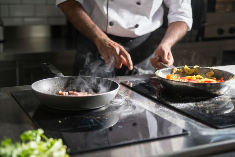 Professional chef cooking on a gas stove in a well-equipped culinary training kitchen.
