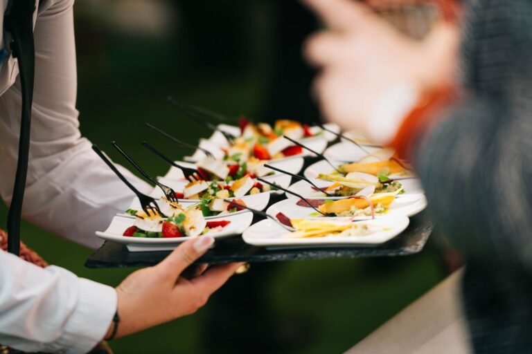 Elegant catering event setup with gourmet food arranged on a professional serving table at a social gathering.