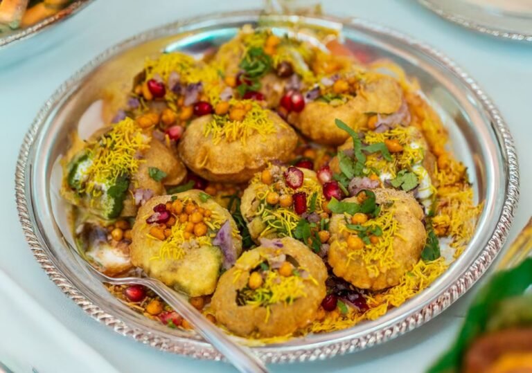 A plate of crispy pani puri topped with colourful chutneys and garnishes — classic Ahmedabad chaat.