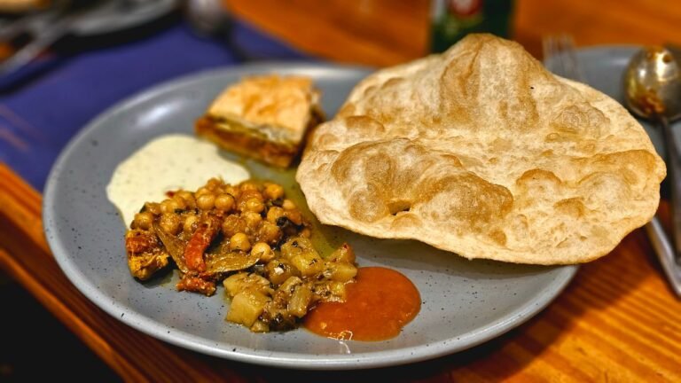 Traditional Indian thali with puri and vegetarian curries — representative of Jain-style Gujarati cooking.