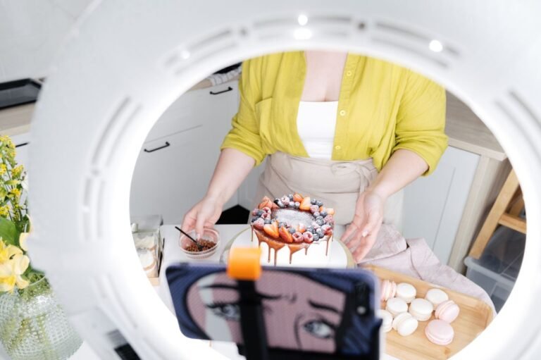 A home baker photographs a decorated cake on her smartphone — capturing the content creation workflow for social media.
