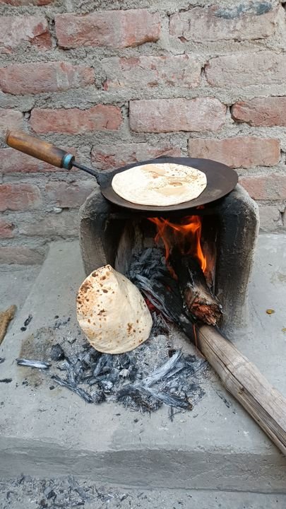 Traditional Indian roti cooking on an open flame, showing the classic puffing stage.