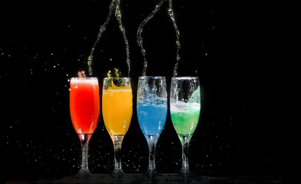 Monsoon Drinks at Home: Iced Teas, Coolers, and Warm Spiced Shakes 4 Refreshing iced drinks with lemon and mint arranged on a wooden table during monsoon season
