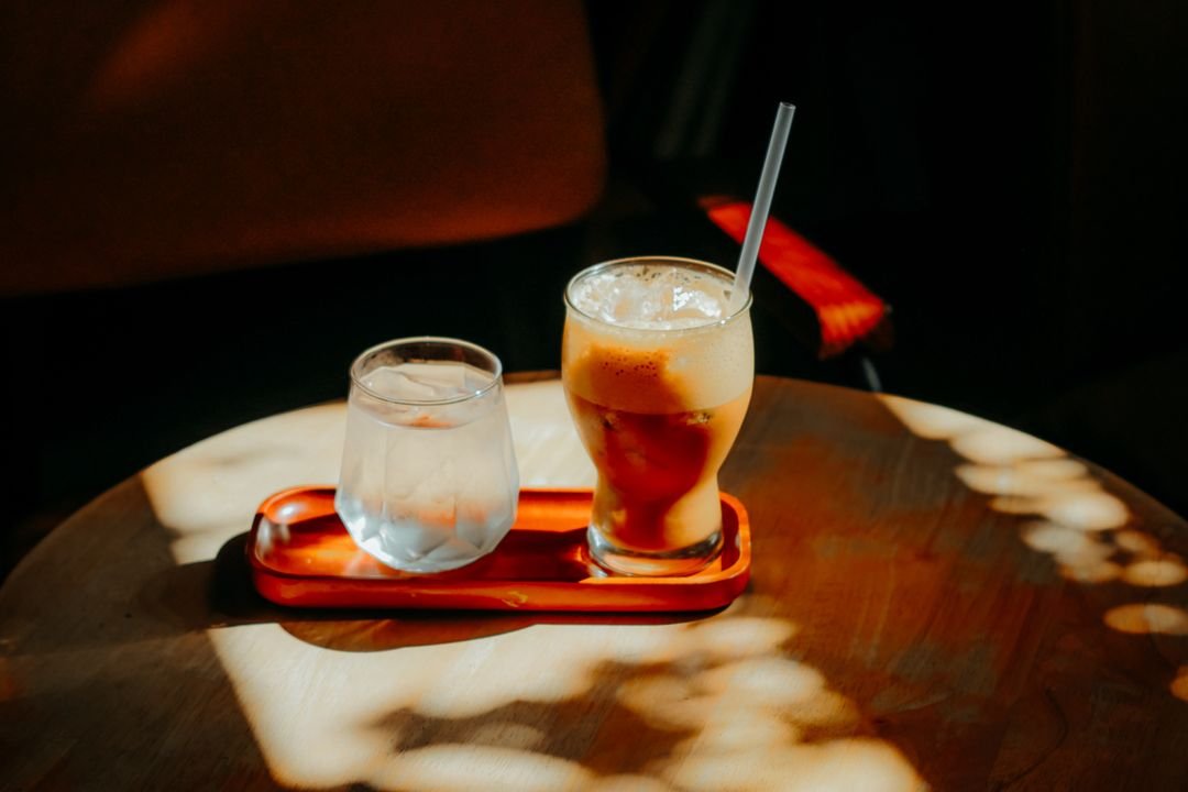 Glass of iced coffee with a straw on a table