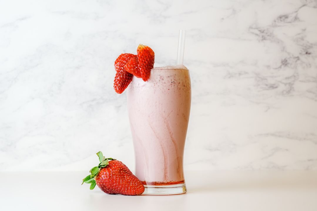 Creamy strawberry milkshake topped with fresh strawberry garnish
