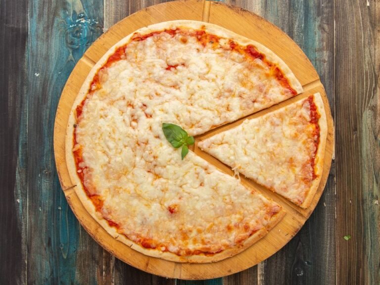 Whole vegetarian Margherita pizza with melted cheese and basil