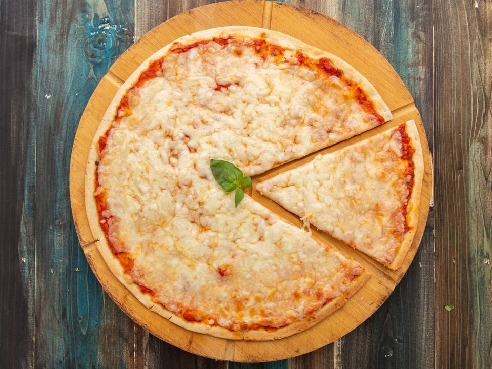 Whole vegetarian Margherita pizza with melted cheese and basil