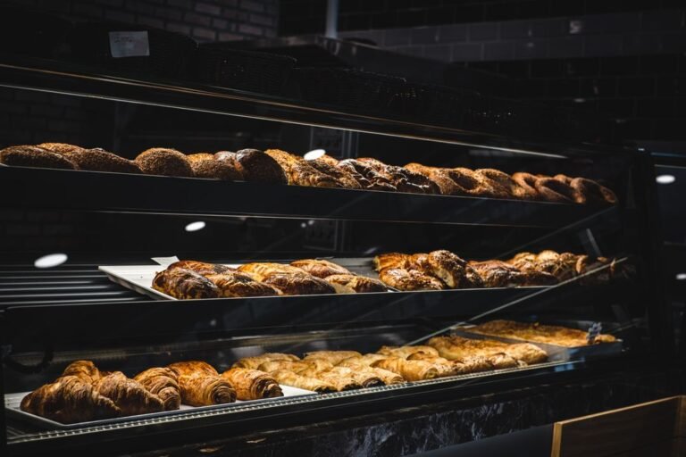 A glass bakery display case filled with freshly baked breads and pastries ready for cafe service.