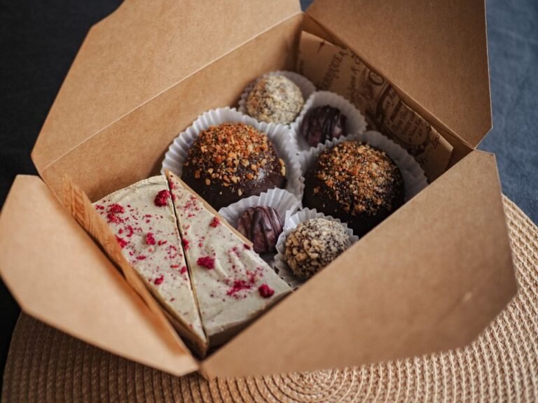Hand-finished chocolate truffles packed in a presentation box, showing the gloss of tempered couverture.
