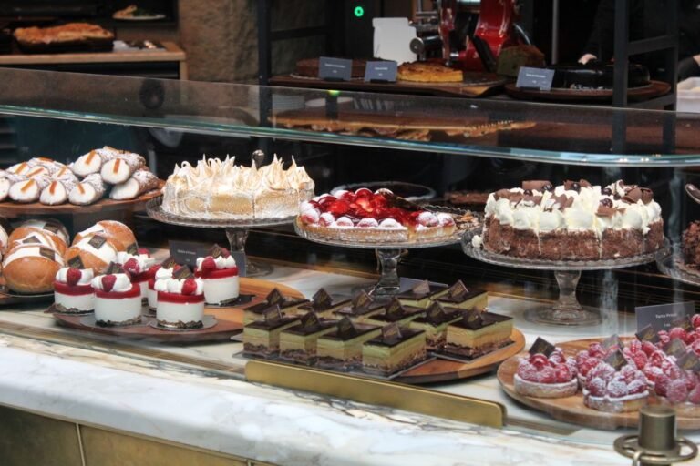 An elegant display of cakes and pastries in a bakery, all made without eggs.