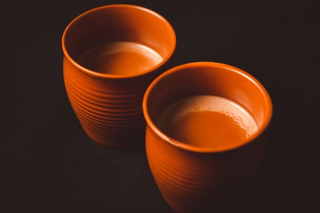 Warm Indian chai served in traditional clay cups on a tray, evoking the Irani cafe tea culture of Gujarat.
