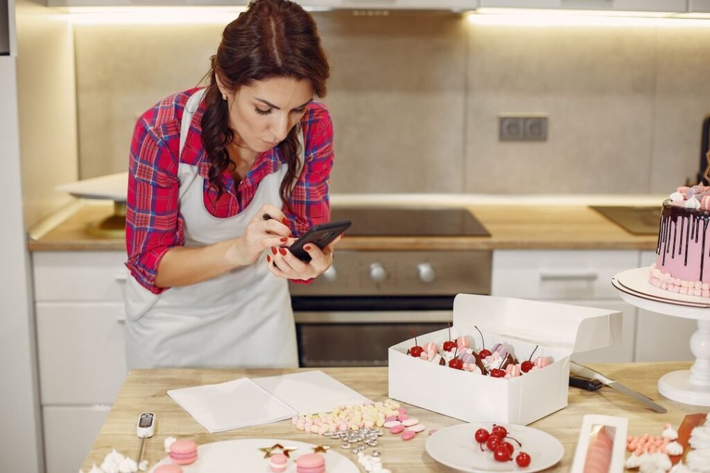 A home baker photographing her desserts on a phone to post to her bakery's Instagram.
