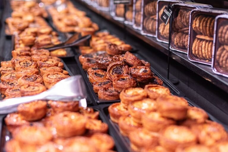 A patisserie window display of French tarts and pastries with crisp shortcrust bases.